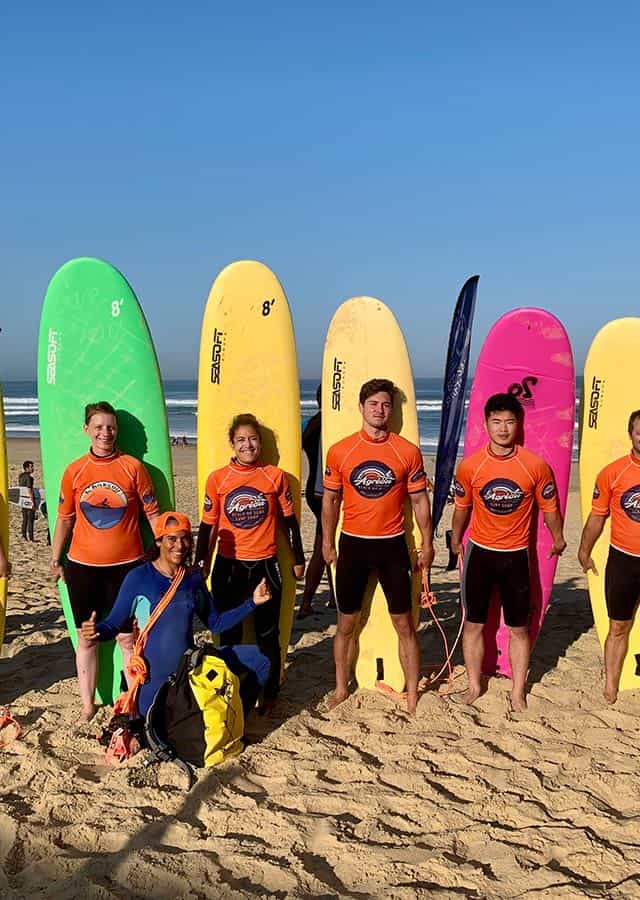 Enfant sur la plage avec planche de surf dans leur dos